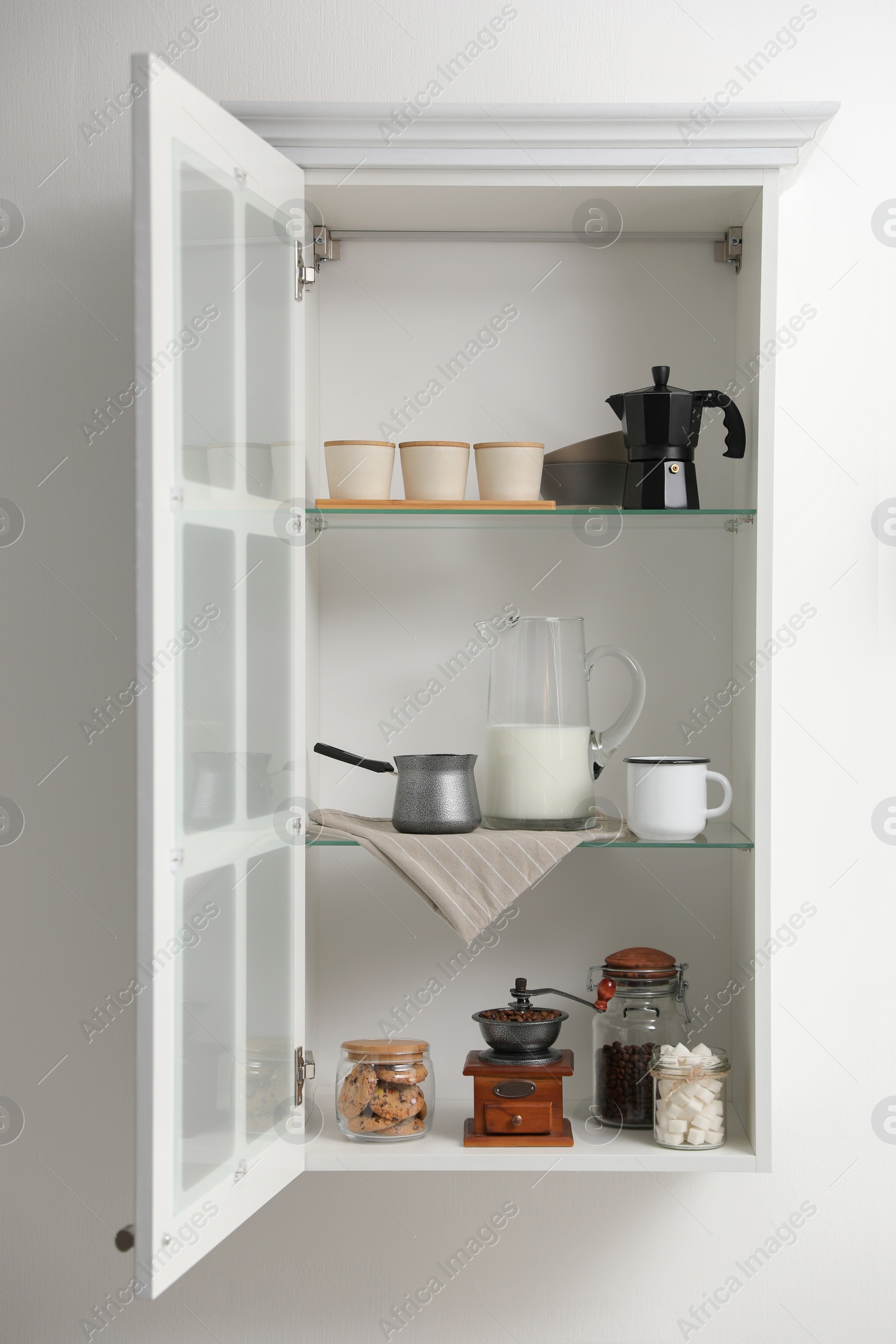 Photo of Vintage coffee grinder and other appliances on shelving unit in kitchen