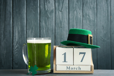 Photo of Composition with green beer and clover on grey wooden table. St. Patrick's Day celebration