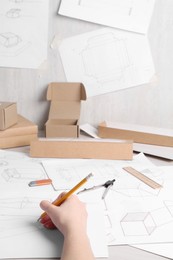 Photo of Woman creating packaging design at table, closeup