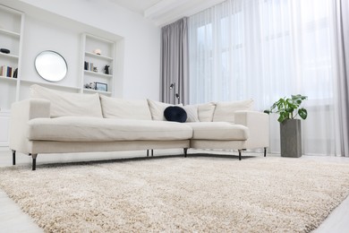 Photo of Fluffy carpet and stylish furniture on floor indoors