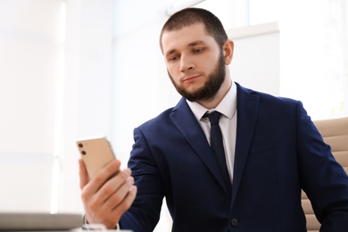 Photo of Man unlocking smartphone with facial scanner indoors. Biometric verification