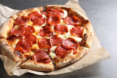 Photo of Tasty hot pepperoni pizza on grey table