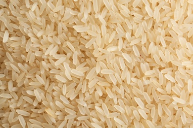 Photo of Raw parboiled rice as background, closeup view
