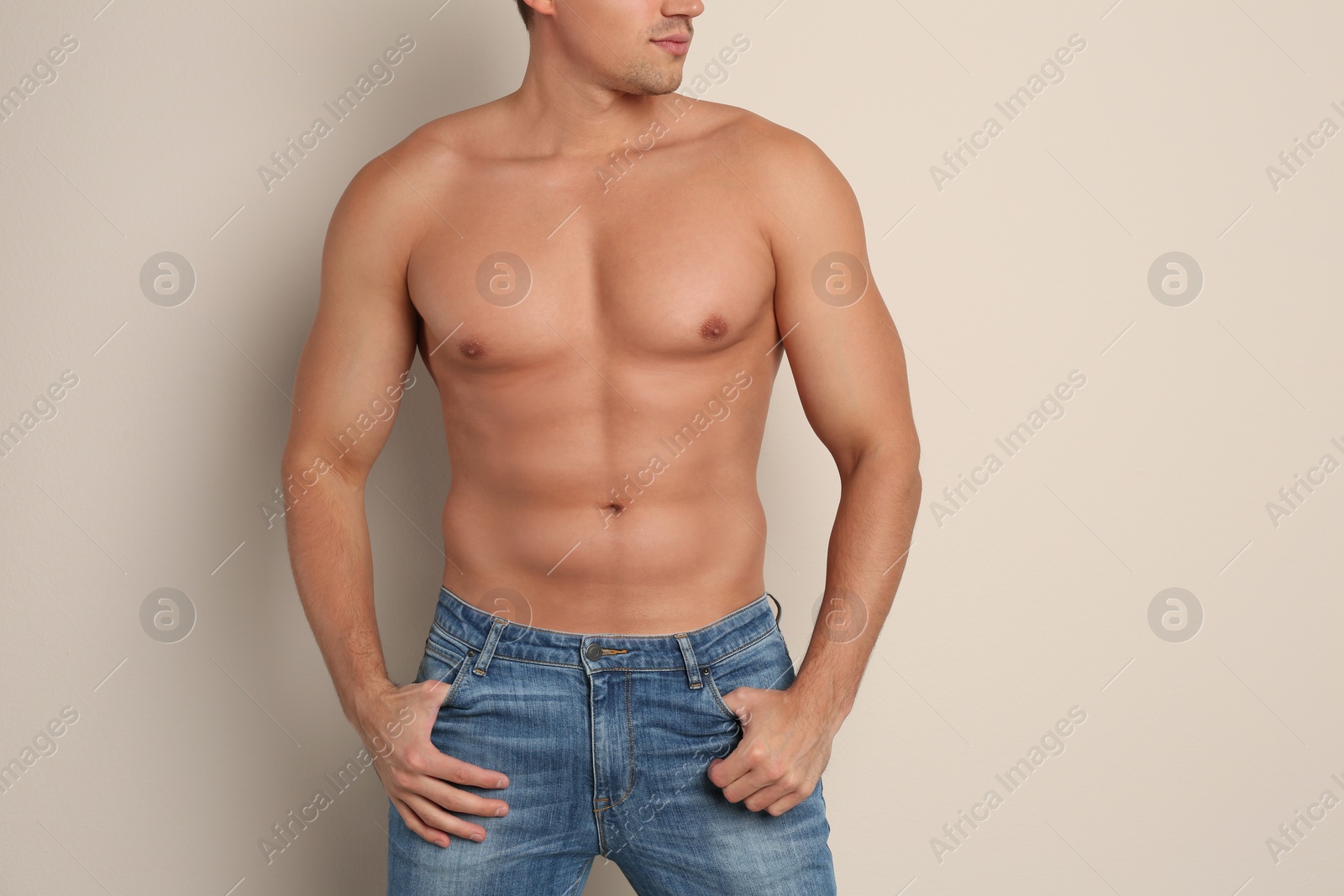 Photo of Man with sexy body on beige background, closeup