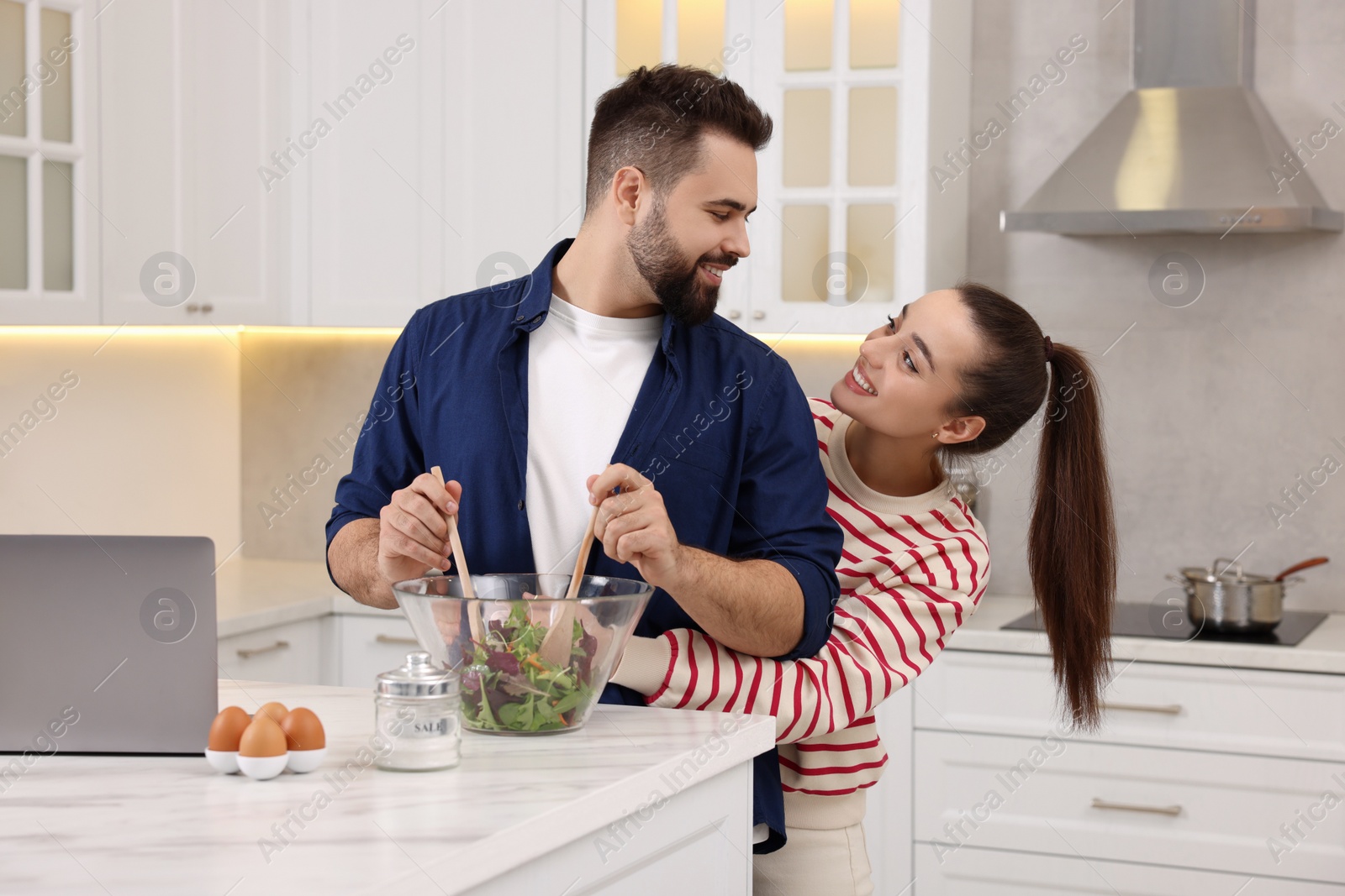 Photo of Happy lovely couple cooking together in kitchen