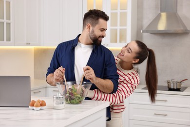 Photo of Happy lovely couple cooking together in kitchen