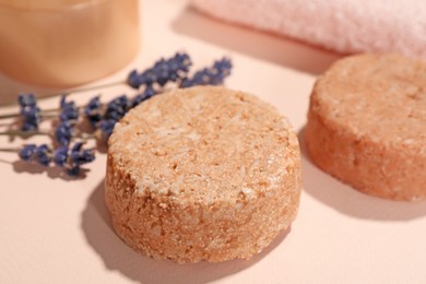 Photo of Solid shampoo bars and lavender on pink background, closeup. Hair care