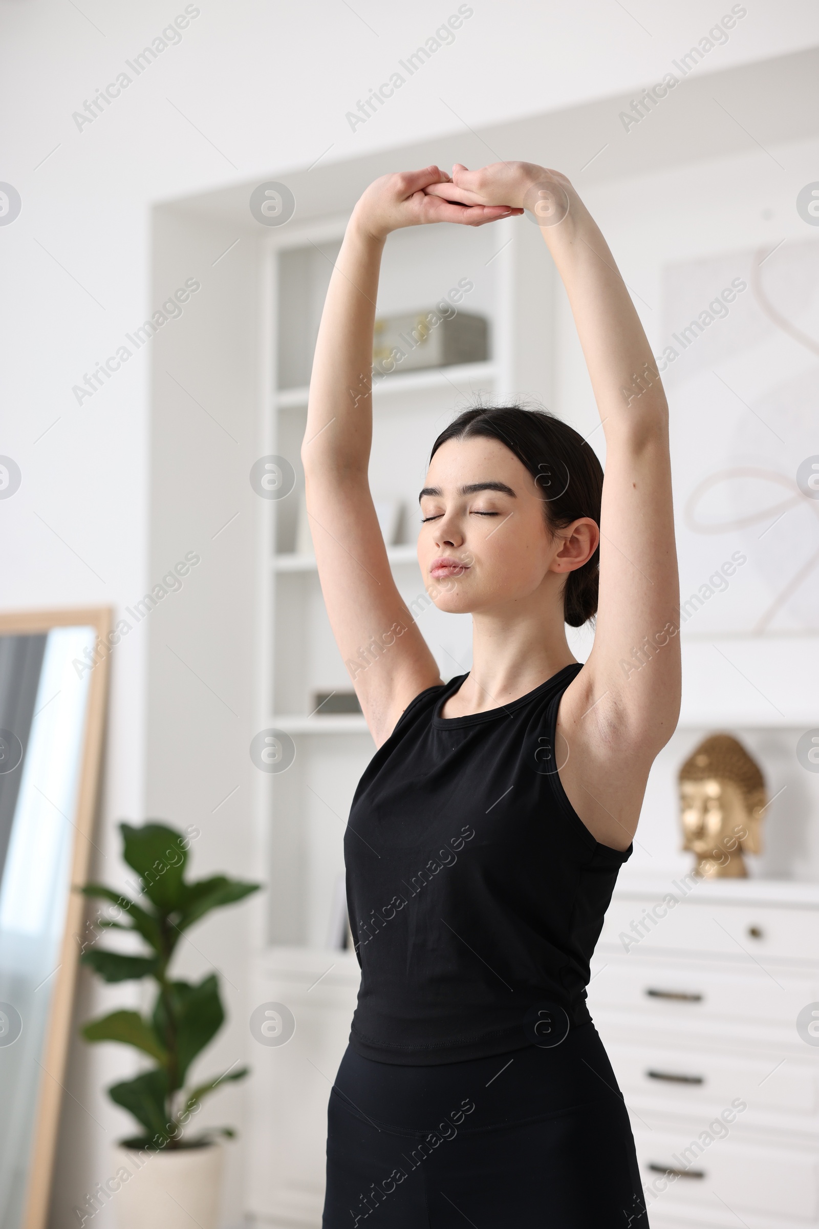 Photo of Portrait of beautiful girl practicing yoga at home