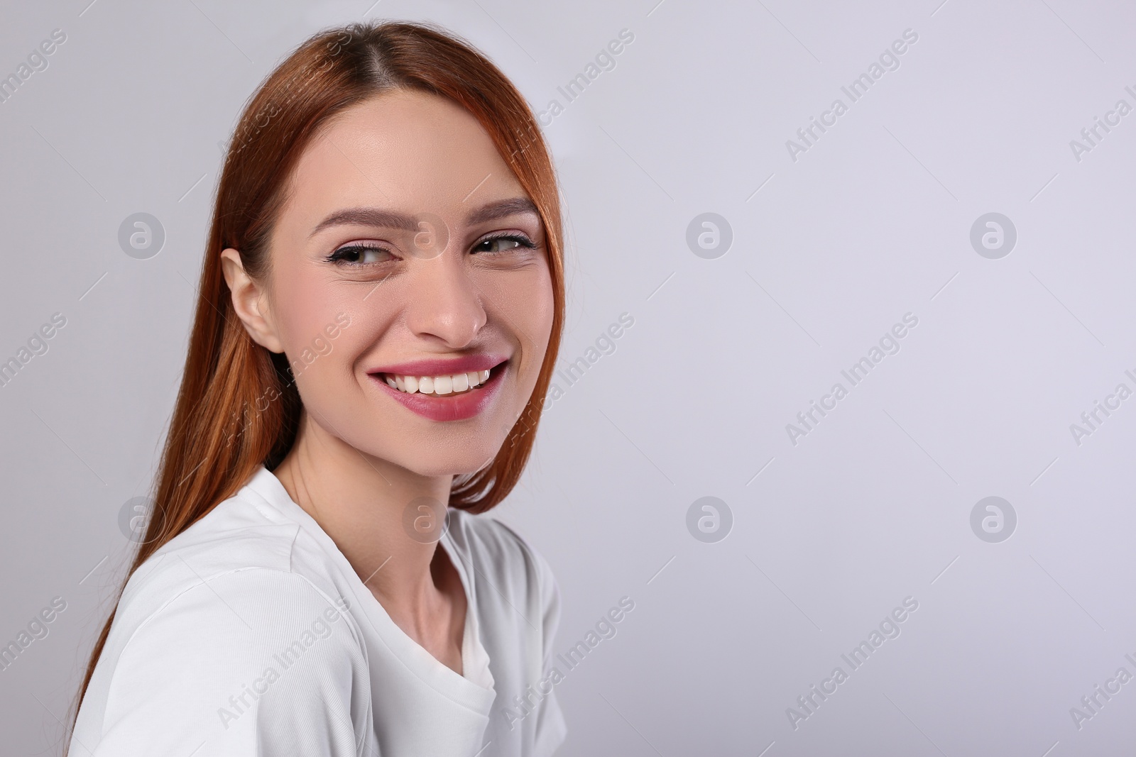 Photo of Portrait of beautiful young woman on light gray background, space for text