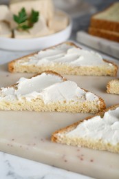 Delicious toasts with tofu cream cheese on white marble table, closeup