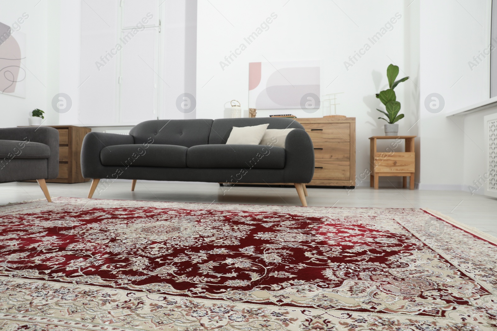 Photo of Cozy room interior with stylish furniture and soft carpet with beautiful pattern