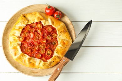 Photo of Tasty tomato galette (Caprese galette) on white wooden table, top view. Space for text