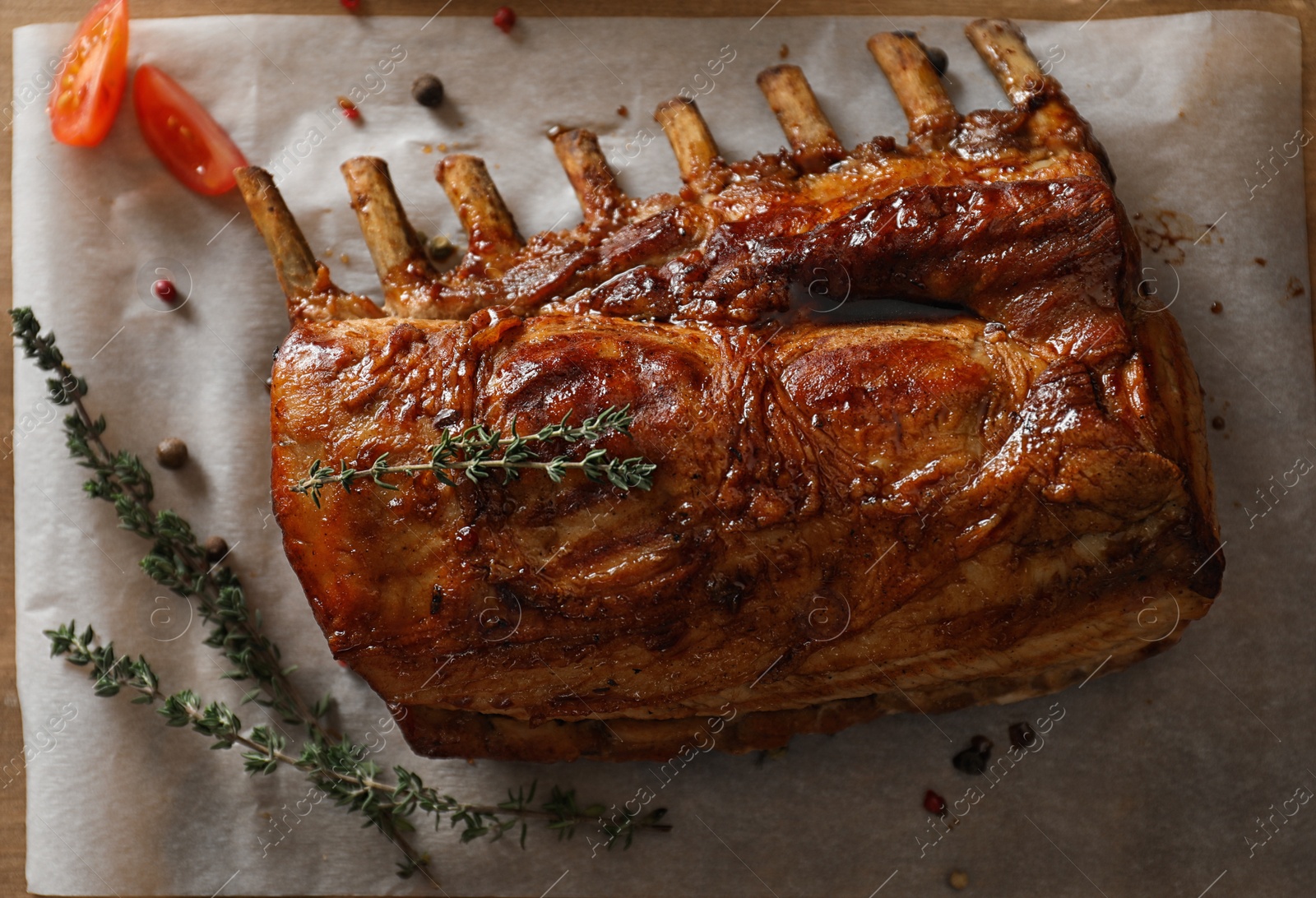 Photo of Delicious roasted ribs served on wooden table, flat lay