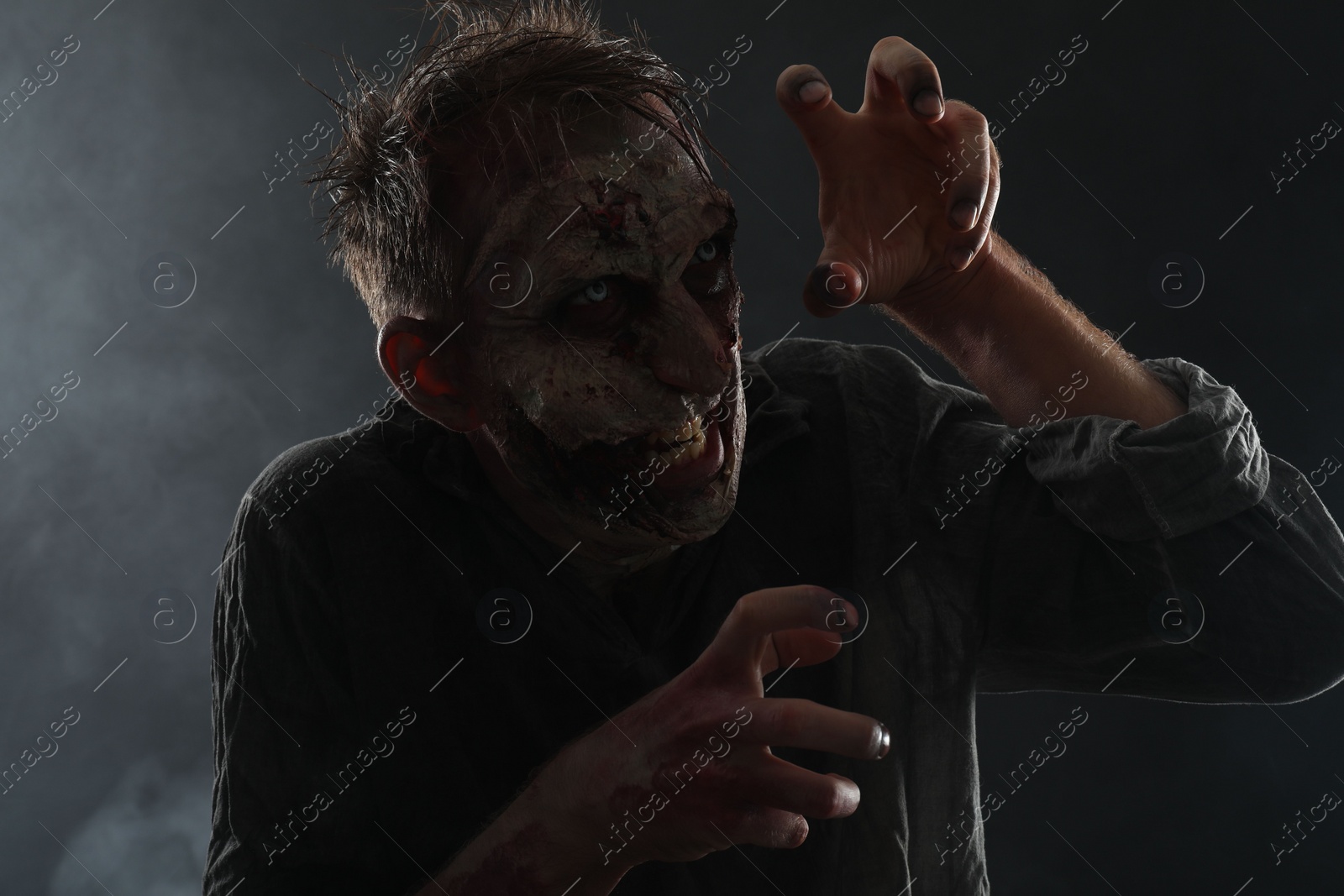 Photo of Scary zombie on dark background. Halloween monster