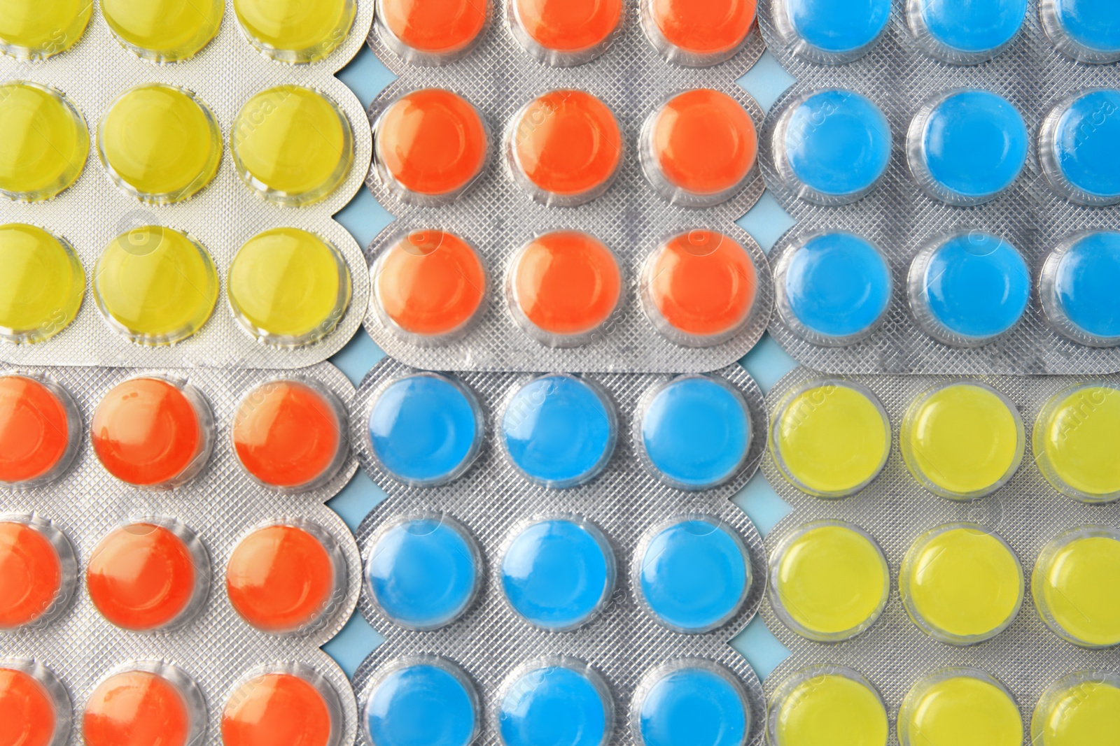 Photo of Blisters with cough drops on light blue background, flat lay