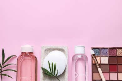 Photo of Flat lay composition with micellar water and cosmetic products on pink background, space for text