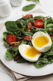 Photo of Delicious salad with boiled egg, bacon and tomatoes on table, closeup