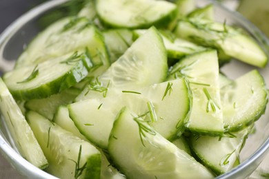 Photo of Cut cucumber with dill in glass bowl, closeup