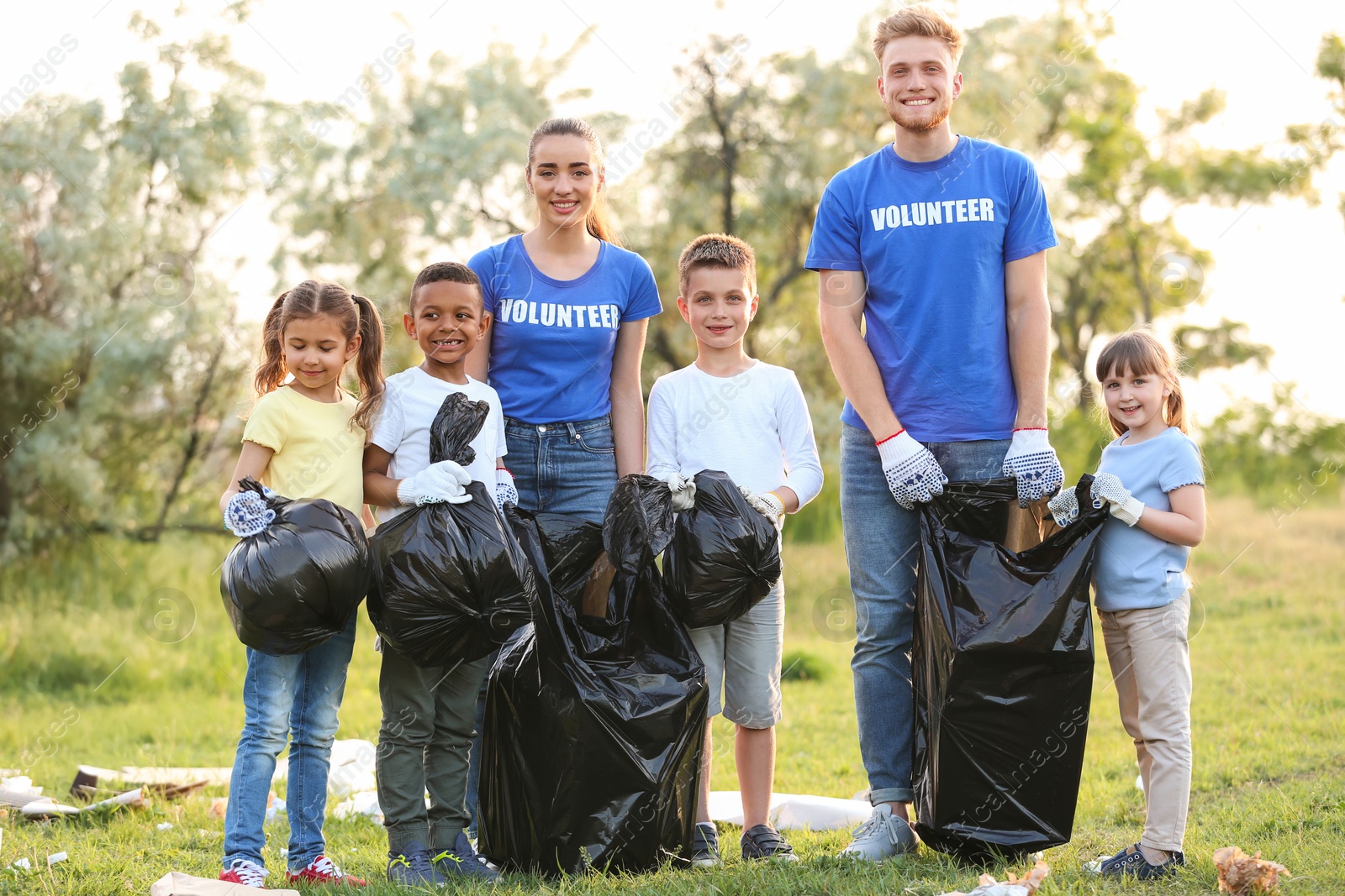 Photo of Volunteers with kids collecting trash in park