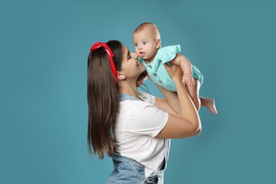 Beautiful mother with her cute baby on blue background. Space for text