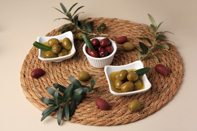 Photo of Olives and tree twigs on beige table