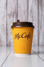 Photo of MYKOLAIV, UKRAINE - AUGUST 12, 2021: Hot McDonald's drink on white wooden table