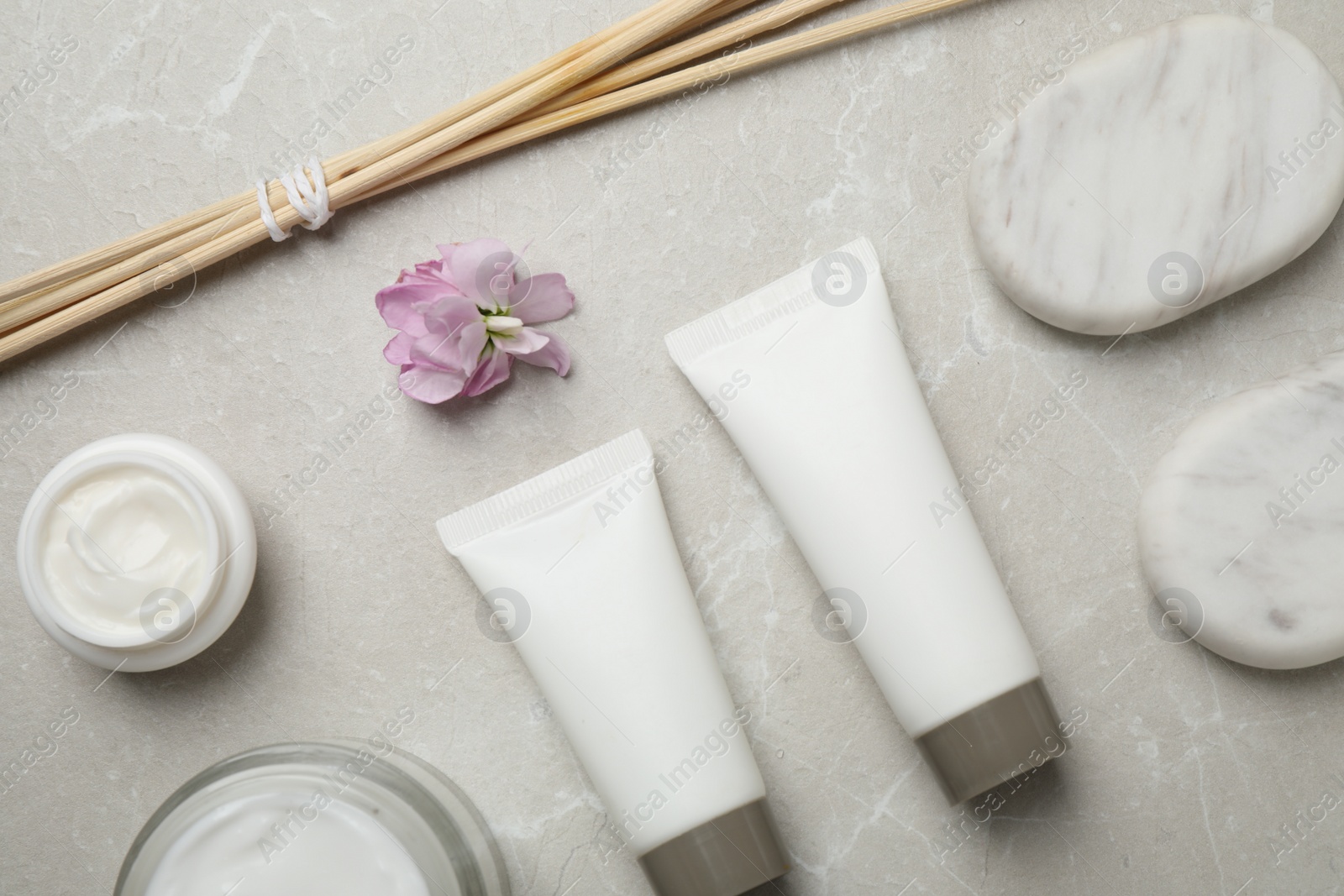 Photo of Flat lay composition with cosmetics on grey marble table. Spa treatment