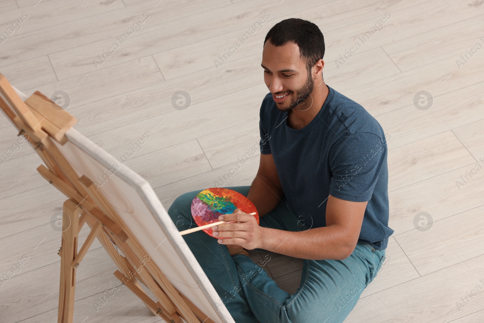 Photo of Young man painting in studio. Creative hobby