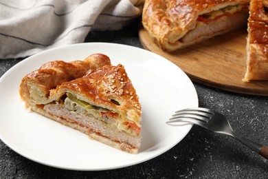 Photo of Piece of tasty homemade pie with filling on black table