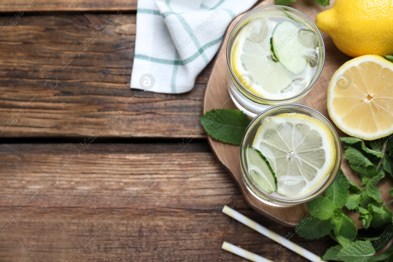 Photo of Refreshing water with cucumber, lemon and mint on wooden table, flat lay. Space for text