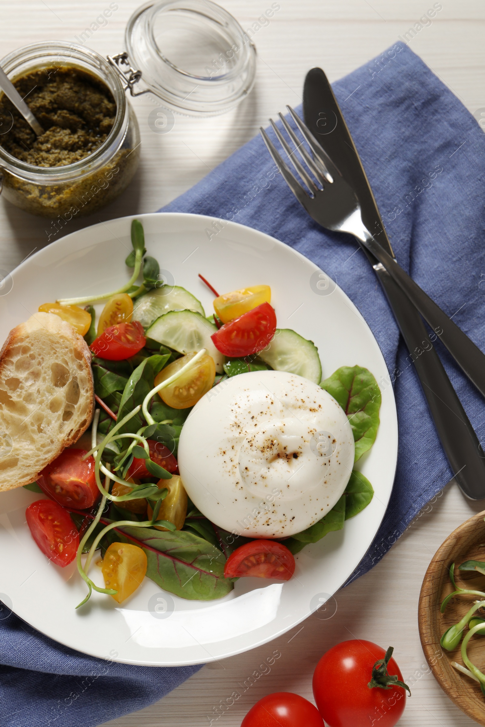 Photo of Delicious burrata salad served on white wooden table, flat lay