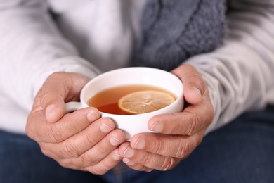 Photo of Man with cup of hot tea for cough, closeup