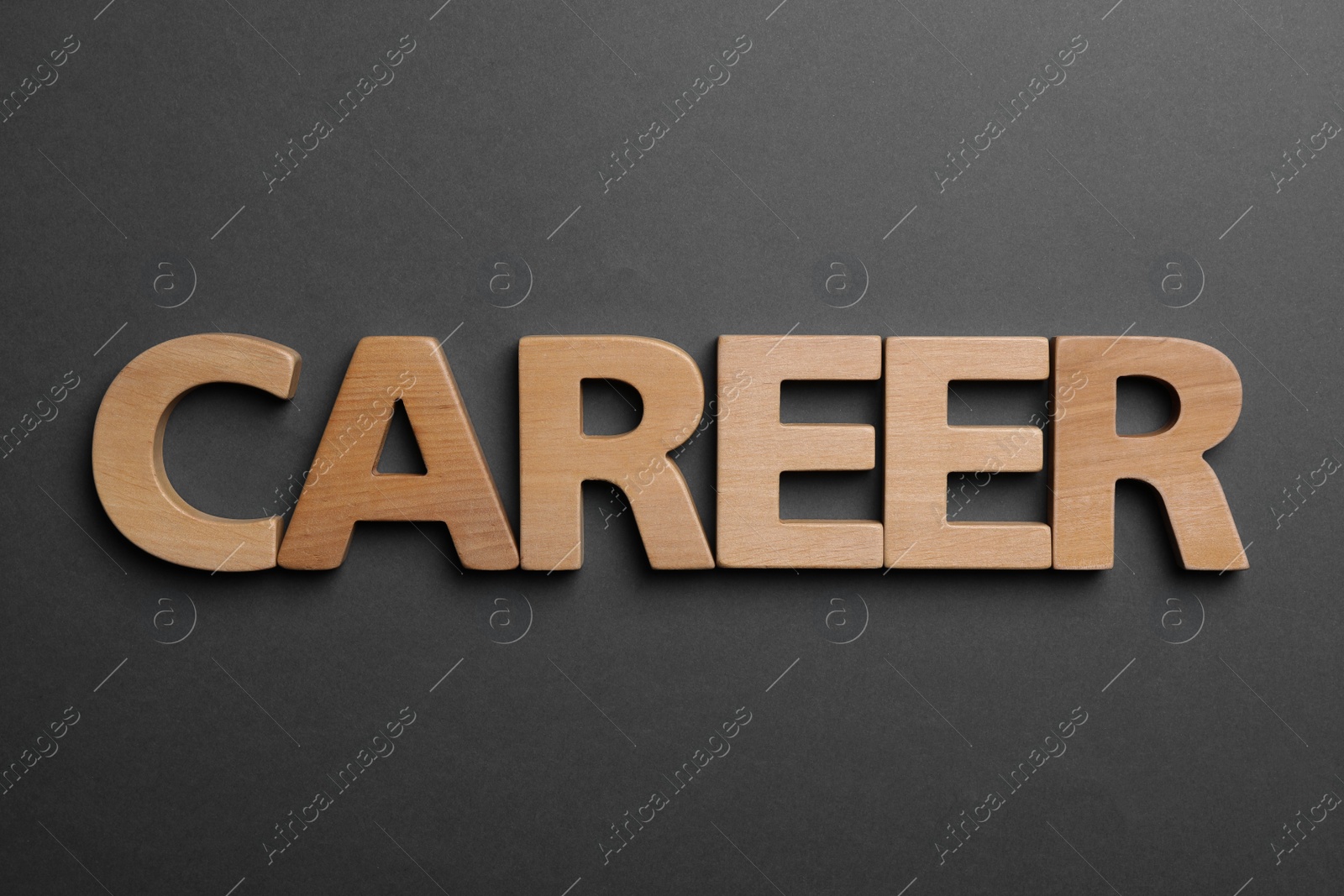 Photo of Word CAREER made with wooden letters on dark background, flat lay