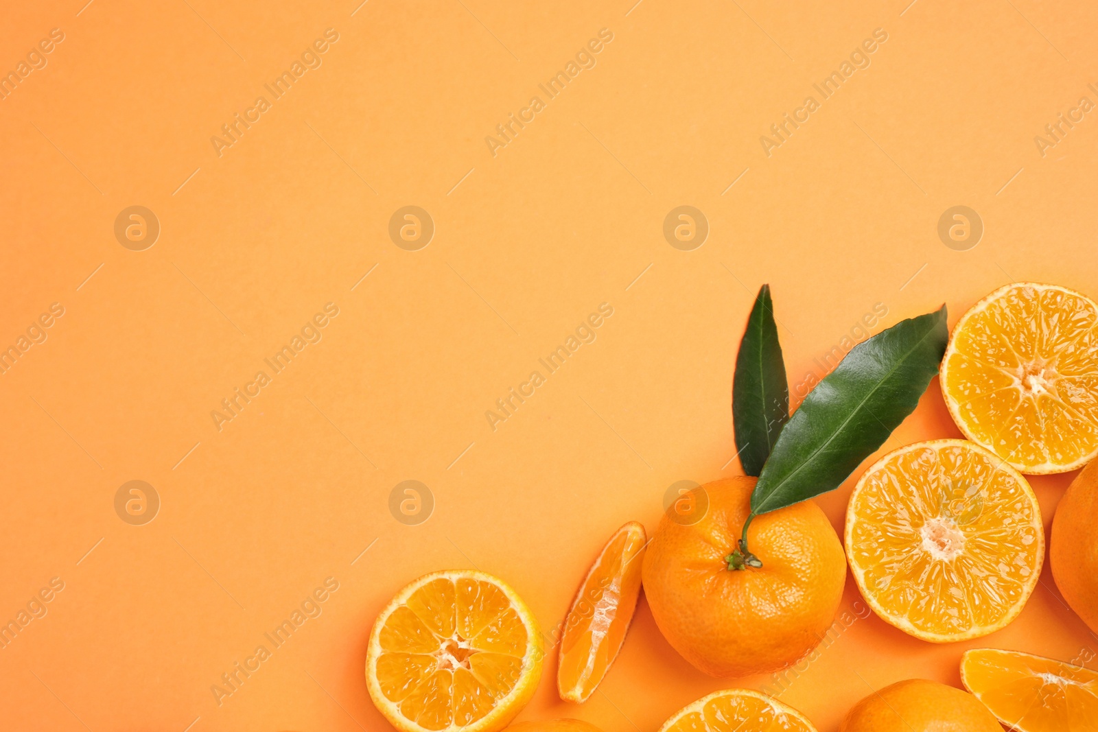 Photo of Flat lay composition with fresh ripe tangerines and space for text on orange background. Citrus fruit