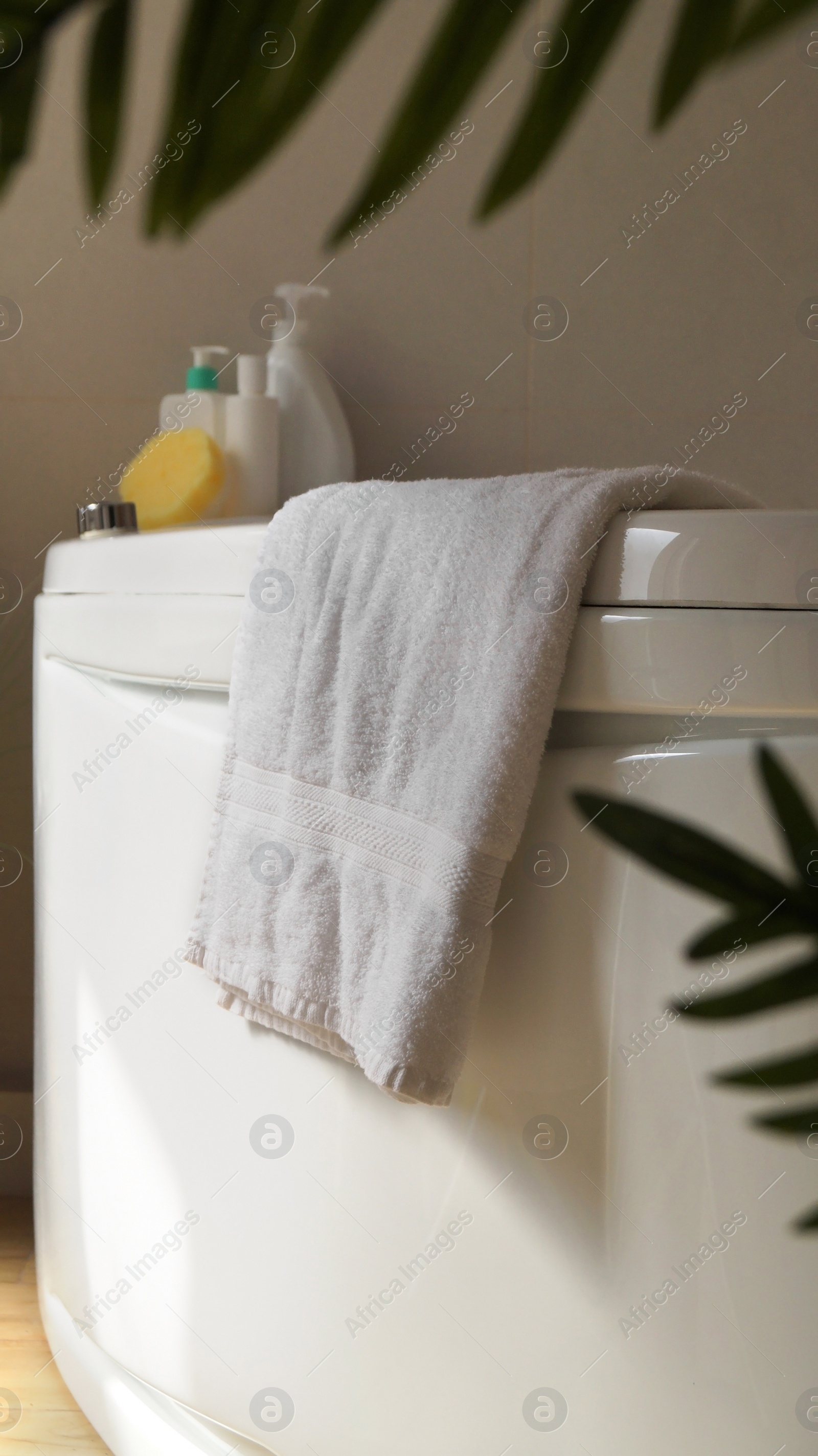 Photo of Soft fluffy towel hanging on bathtub indoors