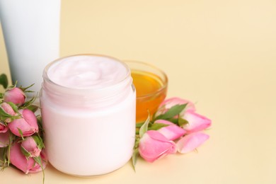 Photo of Different hand care cosmetic products, roses and honey on beige background, closeup. Space for text