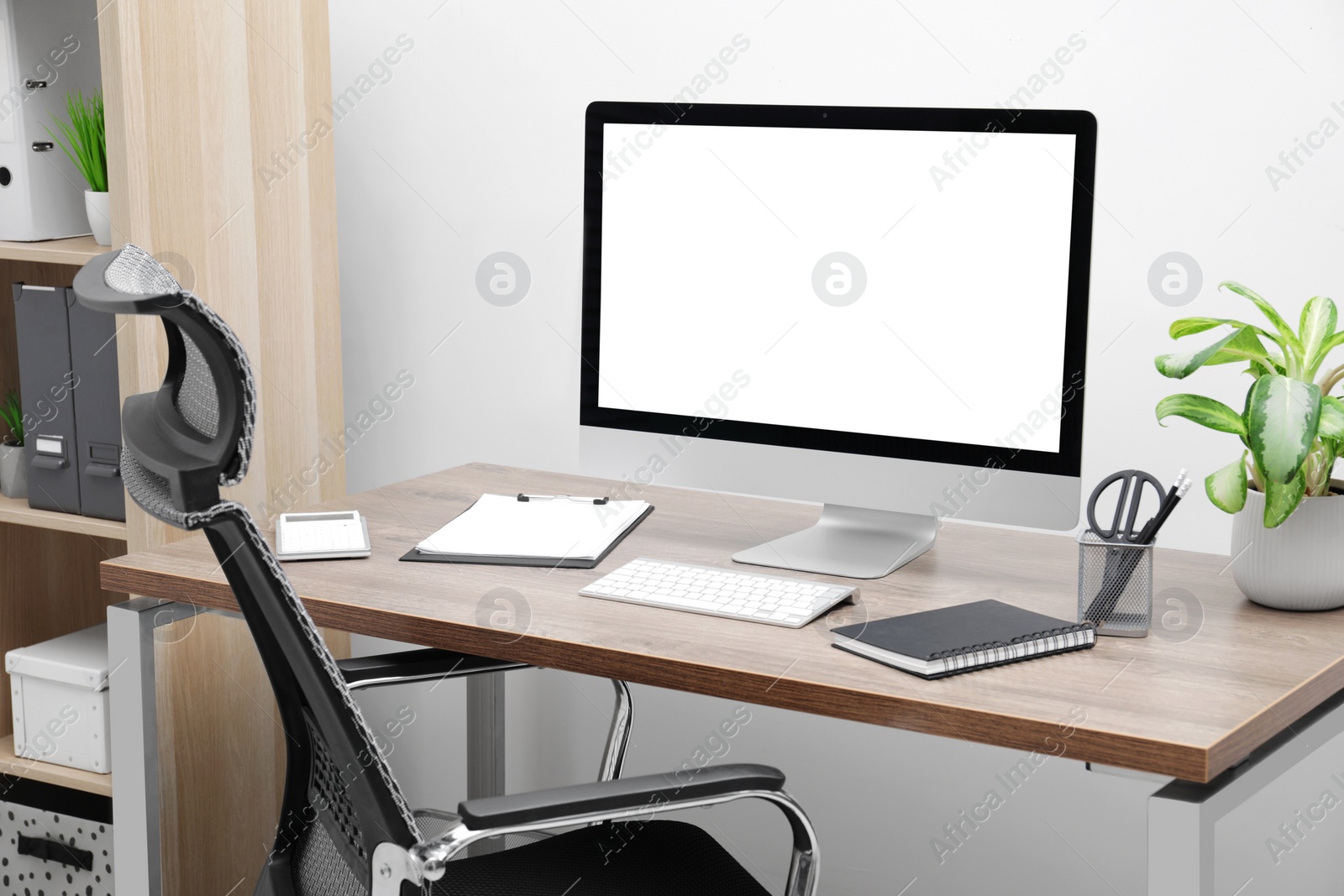 Image of Comfortable workplace at home. Modern computer with blank screen and stationery on wooden desk. Mockup for design