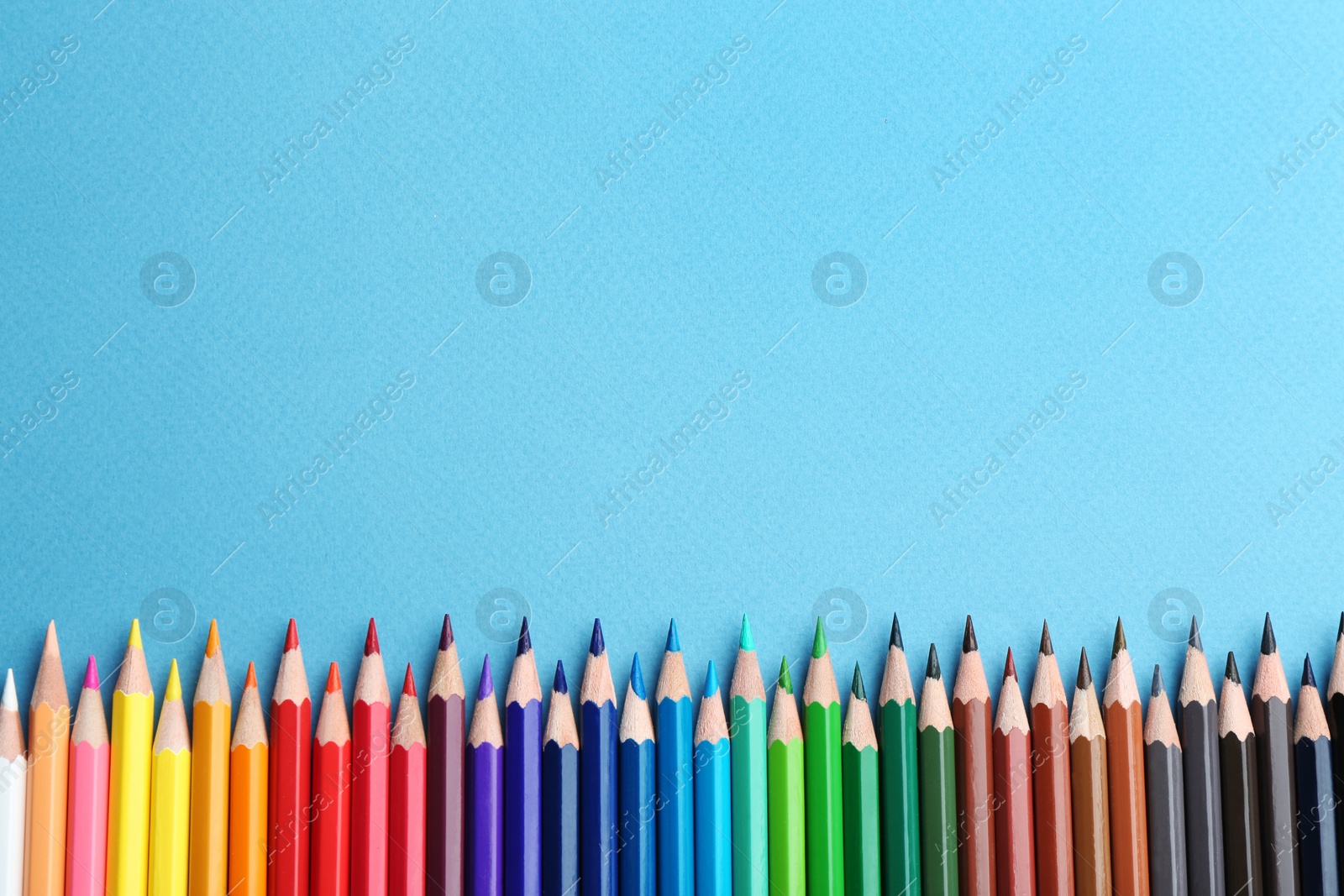 Photo of Flat lay composition with color pencils on blue background. Space for text