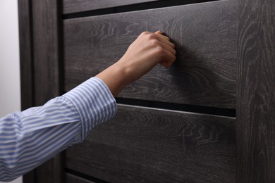 Photo of Woman knocking on door indoors, closeup view