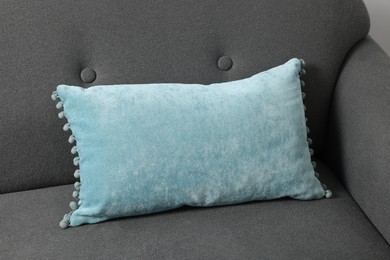 One light blue pillow on grey sofa