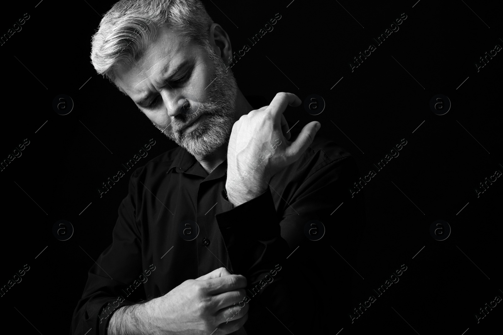 Photo of Portrait of handsome man on dark background. Black and white effect