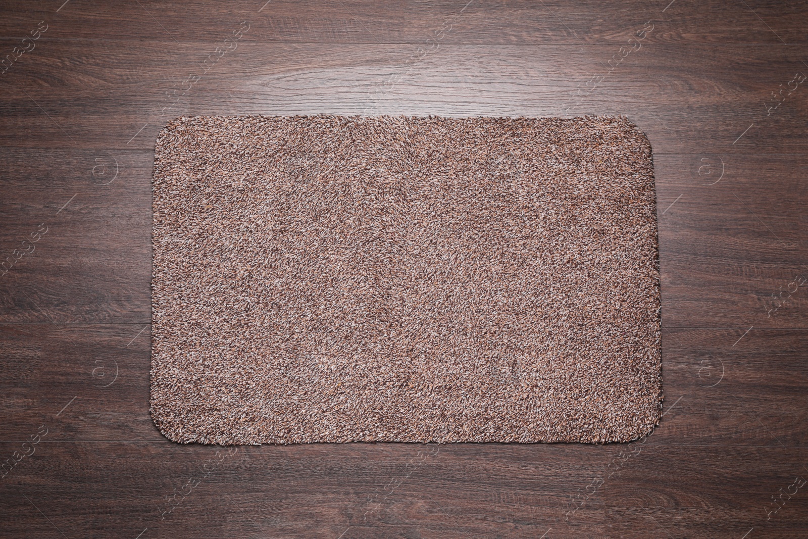 Photo of Stylish door mat on wooden floor, top view