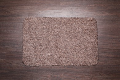 Stylish door mat on wooden floor, top view