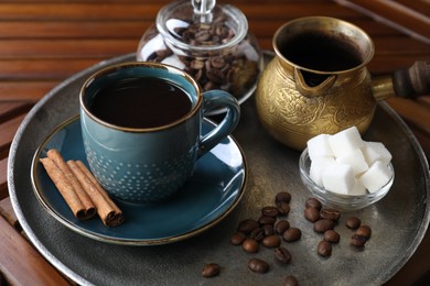 Photo of Turkish coffee. Freshly brewed beverage served on wooden table, closeup