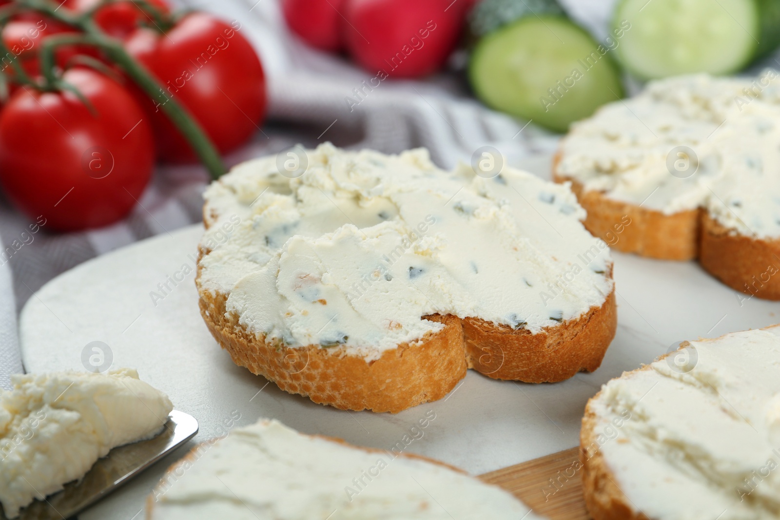 Photo of Toasted bread with cream cheese on board, closeup