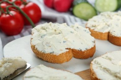 Photo of Toasted bread with cream cheese on board, closeup