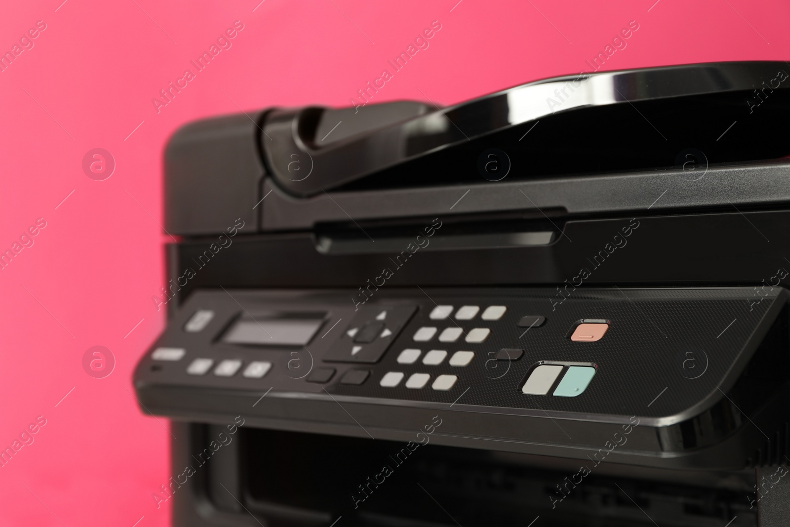 Photo of Closeup view of new modern printer with control panel on pink background, closeup