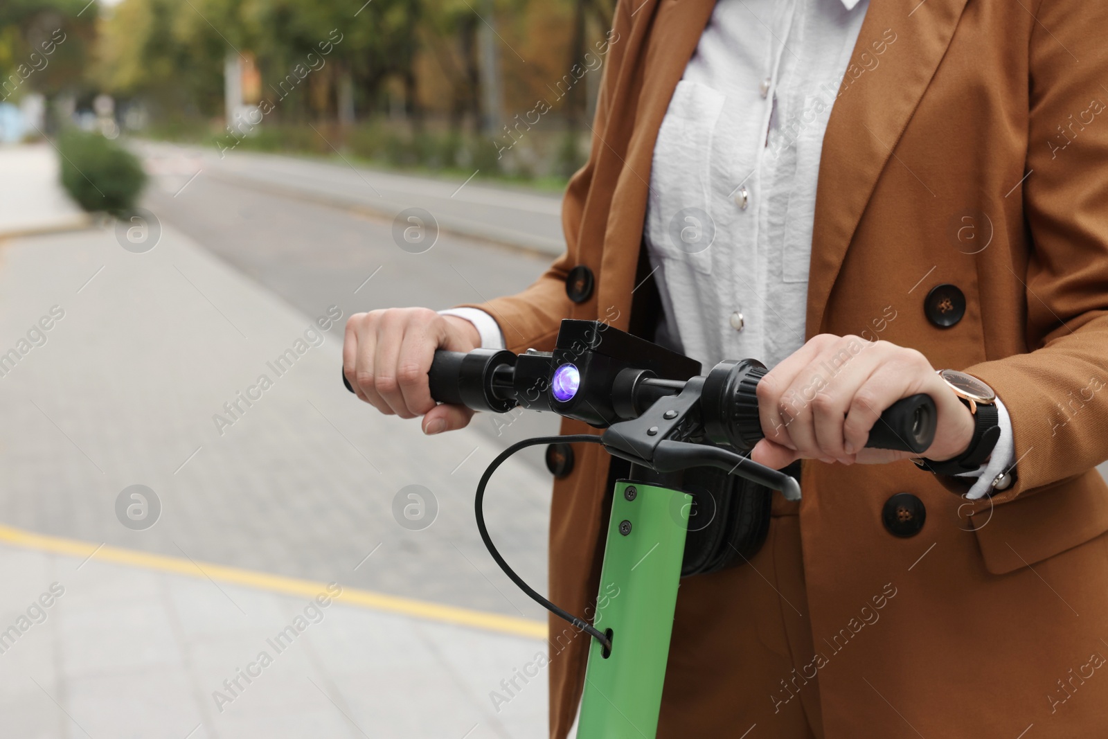 Photo of Businesswoman with modern electric kick scooter on city street, closeup. Space for text