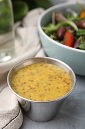 Photo of Tasty vinegar based sauce (Vinaigrette) in bowl on grey table, closeup