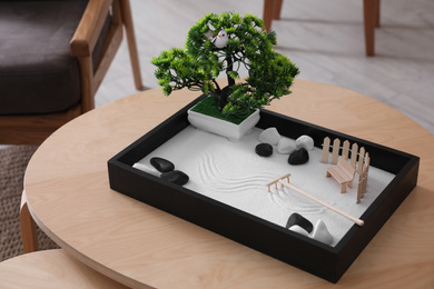 Photo of Beautiful miniature zen garden on wooden table indoors